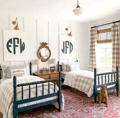 two twin beds in a bedroom with plaid bedding and curtains on the windowsill