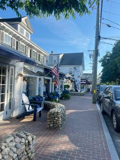 a car parked on the side of a road next to a building with an american flag hanging from it's roof