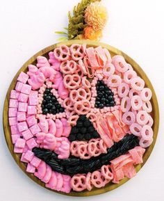 a wooden plate topped with pink and black pretzels