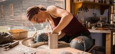 a woman working on pottery in her workshop