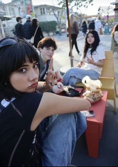 a group of young people sitting on top of a bench