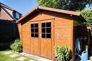 a small wooden shed sitting in the middle of a yard