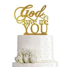 a white cake with gold lettering and flowers on top that says god gave me you