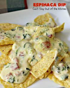 some tortilla chips are on a plate with cheese and spinach dip in the middle