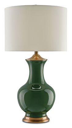 a green table lamp with a white shade on the top and gold trim around the base