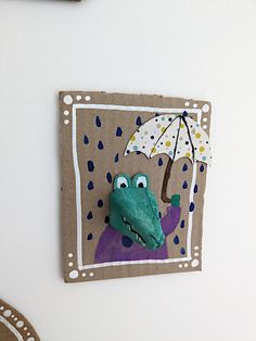 a paper cut out of a crocodile holding an umbrella