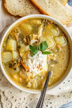 a bowl of vegetable soup with bread on the side