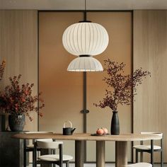 a dining room table with chairs and vases on it