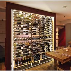 the wine rack is full of bottles and glasses on the table in front of it