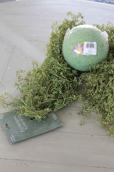 a piece of green stuff sitting on top of a wooden table next to a tag