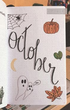 an open notebook with the words october written in black on it, and halloween decorations