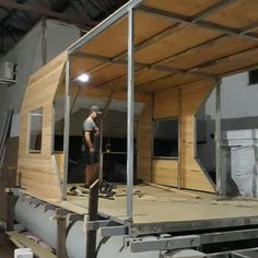 a man standing on top of a wooden floor in front of a building under construction