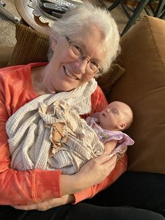 an older woman holding a baby in her arms