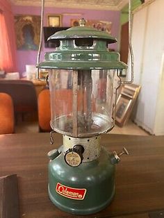 an old green lantern sitting on top of a wooden table