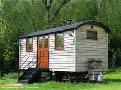 a tiny house sitting on top of a lush green field