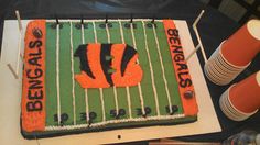 a football field cake is decorated with orange and black icing