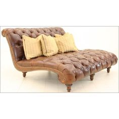 a brown leather chaise lounger with four pillows on it's back and sides