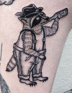 a person with a raccoon tattoo on their leg holding a baseball bat and wearing a hat