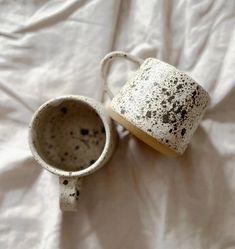 two dirty cups sitting on top of a white sheet