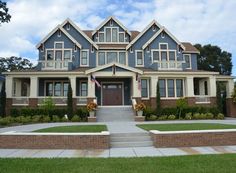 a large blue and white house with lots of windows on it's front porch