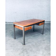 a wooden table with metal legs on concrete floor