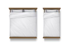 two beds with white sheets and pillows on top of each other in front of a wooden headboard