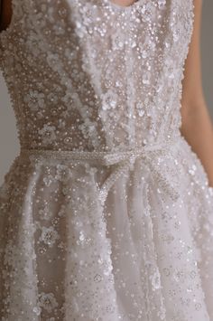 the back of a wedding dress with sequins on it and a belt around the waist