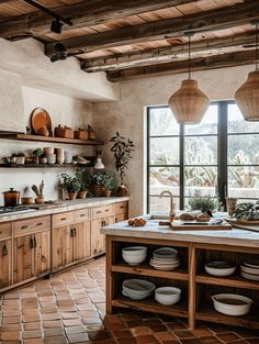 a kitchen filled with lots of wooden cabinets and counter top space next to a window