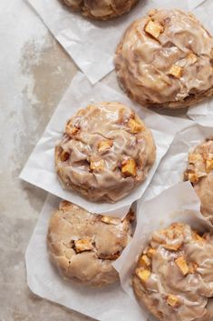 several cookies with icing on top of some white paper