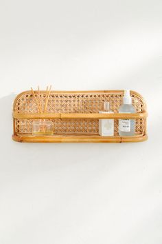 a wooden shelf with some bottles and soaps on top of it in front of a white wall