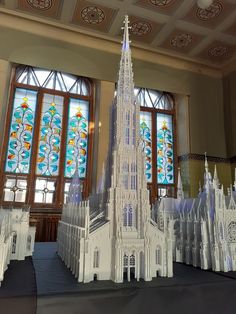 a model of a cathedral in front of stained glass windows