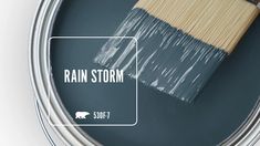 a paint can with the words rain storm painted on it next to a painting brush