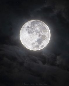 the full moon shines brightly in the night sky with clouds and dark skies behind it