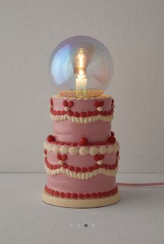 a pink and white cake with a light on top