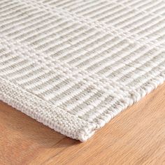 a close up view of a white rug on a wooden floor