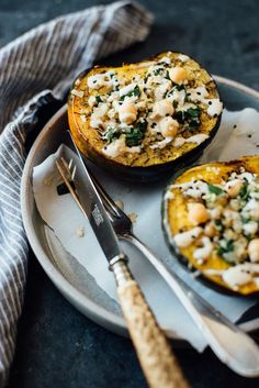 two stuffed acorns with cheese and spinach on a plate next to a fork