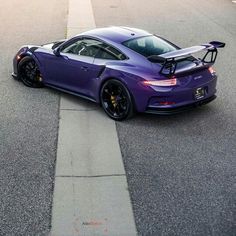 a purple sports car is parked on the street