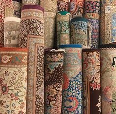 many different colored carpets and rugs are stacked on top of each other in rows