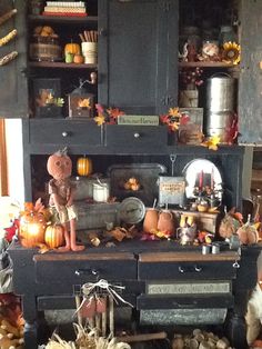 an old fashioned black cabinet with pumpkins and other decorations on it's sides