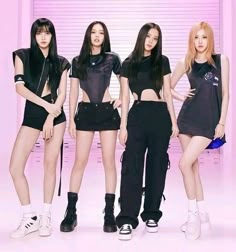 four girls in black outfits standing next to each other with their hands on their hipss