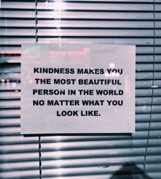 a sign posted on the side of a window that says, kindness makes you the most beautiful person in the world no matter what you look like