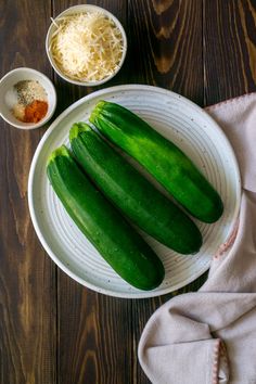 several cucumbers on a white plate with grated cheese