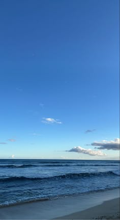 an airplane is flying over the ocean on a clear, blue day with no clouds