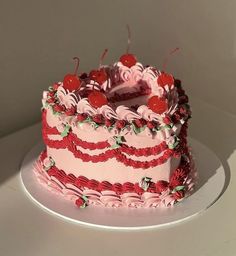 a pink and red cake sitting on top of a white plate