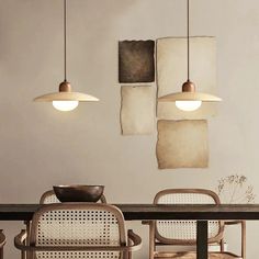 a dining room table with chairs and two hanging lights