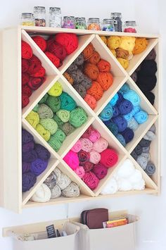 a wooden shelf filled with lots of yarn