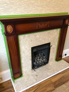 a fireplace with green trim and white marble