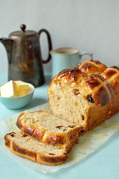 a loaf of bread sitting on top of a piece of wax paper next to a tea pot