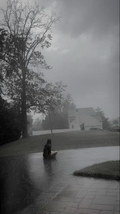 a person sitting in the rain with an umbrella