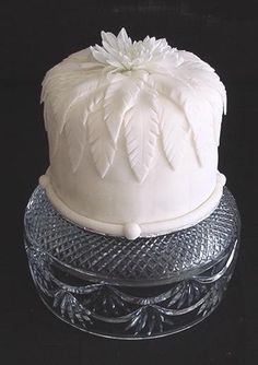 a white cake sitting on top of a glass plate